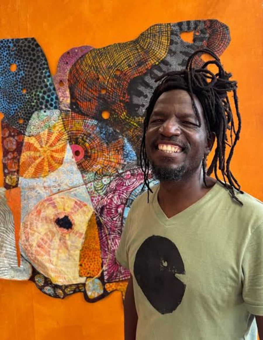 Johnson Zuze standing beside one of his scrap metal sculptures