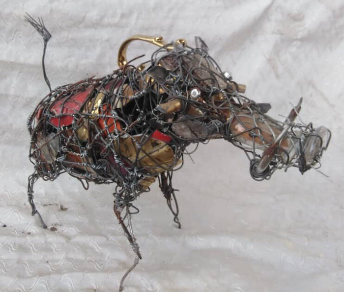 Warthog built from wire with brass tusks and bottle caps